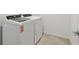 Laundry room features a full-size washer and dryer, with neutral tile flooring at 10524 Hidden Banks Gln, Parrish, FL 34219