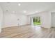 Bright living room with hardwood floors, white walls, and sliding glass doors to the backyard at 10524 Hidden Banks Gln, Parrish, FL 34219