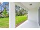 Covered patio showcasing views of lush green lawn and mature trees at 10524 Hidden Banks Gln, Parrish, FL 34219