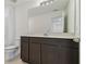 This bathroom offers a large vanity with dark wood cabinets and stone countertop at 10541 Hidden Banks Gln, Parrish, FL 34219