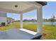 A covered patio offers scenic views of the tranquil lake and lush green lawn at 10541 Hidden Banks Gln, Parrish, FL 34219
