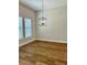 Neutral bedroom featuring wood-look floors, black hanging light fixture and well-lit by two windows at 13400 Haflinger Way, Hudson, FL 34667