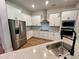 Modern kitchen boasts stainless steel appliances, white cabinets, and a quartz countertop island at 13400 Haflinger Way, Hudson, FL 34667
