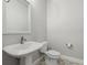 Simple bathroom with pedestal sink, toilet, and patterned floor at 1532 Gopher Loop, Tarpon Springs, FL 34689