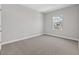 Simple bedroom with grey carpet and a window at 1532 Gopher Loop, Tarpon Springs, FL 34689