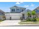 Two-story house with light blue siding, white garage, and landscaping at 1532 Gopher Loop, Tarpon Springs, FL 34689