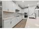 Modern kitchen with white cabinets, quartz countertops, and stainless steel appliances at 1532 Gopher Loop, Tarpon Springs, FL 34689