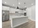 Modern kitchen with white cabinets, quartz countertops, and stainless steel appliances at 1532 Gopher Loop, Tarpon Springs, FL 34689