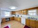 Bright kitchen with wood cabinets, white appliances, and laminate flooring at 162 S Saint Thomas Cir, Apollo Beach, FL 33572
