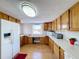 Kitchen with wood cabinets, white appliances, and laminate flooring at 162 S Saint Thomas Cir, Apollo Beach, FL 33572