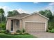One-story home with light brown exterior, two-car garage, and landscaped front yard at 17778 Solstice Ave, Venice, FL 34293