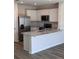 Bright kitchen featuring white cabinets, stainless steel appliances, and a large island at 4588 Pleasant Ave, Palm Harbor, FL 34683