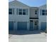 Charming townhome featuring a one-car garage and light blue accents at 4592 Pleasant Ave, Palm Harbor, FL 34683