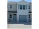 Light blue townhouse features a one-car garage and charming architectural details at 4600 Pleasant Ave, Palm Harbor, FL 34683