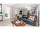 Bright living room featuring a dark blue sofa, decorative pillows, and light wood flooring at 702 E Gilchrist St, Plant City, FL 33563