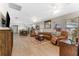 Open concept living room with hardwood floors, leather furniture, and ceiling fans at 702 E Gilchrist St, Plant City, FL 33563