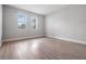 Bedroom with wood-look floors and two windows at 10800 Us 19 N. # 230, Pinellas Park, FL 33782
