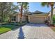 Tan house with gray shutters, paver driveway, and palm trees at 11519 Coventry Grove Circle, Lithia, FL 33547