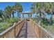 Scenic boardwalk leading to the beach with gazebo and tropical plants at 1200 Gulf Blvd # 1104, Clearwater Beach, FL 33767