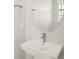 Close up of the pedestal sink and round mirror with a silver faucet and hardware at 12170 Meditation Trl, Venice, FL 34293