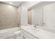 Bright bathroom featuring tiled walls, large mirror, white vanity, and bathtub with shower at 12170 Meditation Trl, Venice, FL 34293
