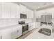 Stunning kitchen with white cabinetry, stainless steel appliances, an island, and sleek countertops at 12170 Meditation Trl, Venice, FL 34293