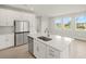 Bright kitchen features stainless steel appliances, a large island, and ample white cabinetry at 12170 Meditation Trl, Venice, FL 34293