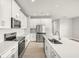 Modern kitchen featuring white cabinets, stainless steel appliances, stone countertops, and modern fixtures at 12170 Meditation Trl, Venice, FL 34293