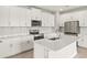 Bright kitchen with white cabinets, stainless steel appliances, stone countertops, and tile backsplash at 12170 Meditation Trl, Venice, FL 34293