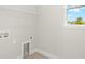 Neutral laundry room with shelving and a window offering natural light at 12170 Meditation Trl, Venice, FL 34293