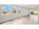 Living room featuring tile flooring and bright windows with beautiful views of the surrounding neighborhood at 12170 Meditation Trl, Venice, FL 34293