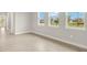 Living room features tile flooring, white walls, and abundant natural light from large windows at 12170 Meditation Trl, Venice, FL 34293