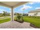 The house has an open patio with brick ground looking out onto a grassy, landscaped yard at 12170 Meditation Trl, Venice, FL 34293