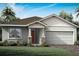 One-story home with gray siding, brown roof, and red door at 12211 Meditation Trl, Venice, FL 34293