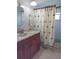 Bathroom with wood vanity, shower, and palm-themed curtain at 12788 91St Ave, Seminole, FL 33776