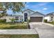 Beautiful light blue house with a two-car garage and landscaped front yard at 13010 Tribute Dr, Riverview, FL 33578