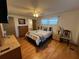Bedroom featuring a comfortable bed, wood-look floors, and windows at 13225 101St St # 451, Largo, FL 33773