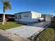 Exterior shot of home featuring a well-maintained driveway, a covered carport, and tidy landscaping at 13225 101St St # 451, Largo, FL 33773