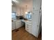 Cozy kitchen with white cabinets, wood-look flooring, and ample counter space for meal preparation at 13225 101St St # 451, Largo, FL 33773