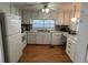 Bright kitchen featuring white appliances, ample cabinetry, and a large window at 13225 101St St # 451, Largo, FL 33773