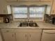 Well-lit kitchen featuring a double sink with a view, marble-look countertops, and ample cabinet storage at 13225 101St St # 451, Largo, FL 33773