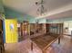 Unfinished living room features a yellow entry door and an ornate chandelier at 14016 Marguerite Dr, Madeira Beach, FL 33708