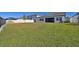 Expansive grassy backyard, enclosed by white and black fencing, extends from a modern white home at 21291 Snowy Orchid Ter, Land O Lakes, FL 34637