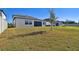 House backyard with grassy area and partial view of the house at 21291 Snowy Orchid Ter, Land O Lakes, FL 34637