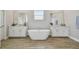 Elegant bathroom featuring a freestanding tub, double vanities, and wood-look tile flooring at 21291 Snowy Orchid Ter, Land O Lakes, FL 34637