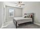 This bedroom features a metal frame bed, neutral walls, base trim, and natural light from a window at 21291 Snowy Orchid Ter, Land O Lakes, FL 34637