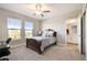 Well-lit bedroom featuring carpeted floors, windows, and direct access to an ensuite bathroom at 21291 Snowy Orchid Ter, Land O Lakes, FL 34637
