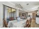 Bright dining room with stylish chandelier, sliding glass doors to patio, and open view to the kitchen and living room at 21291 Snowy Orchid Ter, Land O Lakes, FL 34637
