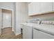 Laundry room with washer, dryer, sink, cabinet, and wood-look tile flooring at 21291 Snowy Orchid Ter, Land O Lakes, FL 34637