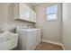 This laundry room features a washer and dryer, sink, wood-look tile flooring, and bright natural light at 21291 Snowy Orchid Ter, Land O Lakes, FL 34637